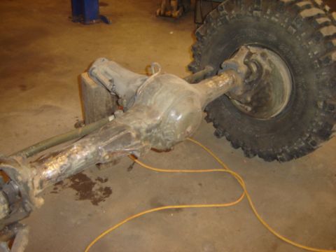 1992 Ford Bronco - Close-up of a heavy-duty rear axle assembly and tire in a workshop setting.