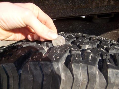 1995 Ford C-150 (Centurion Conversions) - A quarter is used to check the tread depth of a vehicle tire.