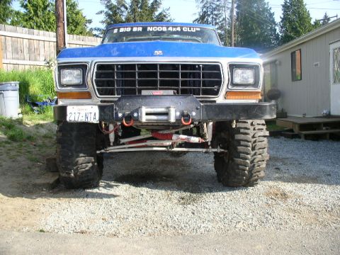 1979 Ford Bronco - Frontal view of a lifted blue 1978 Ford Bronco with off-road tires and a winch mounted on the bumper.