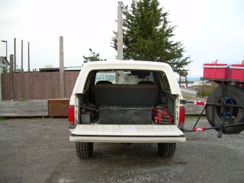 1991 Ford Bronco - Rear view of a 1991 Ford Bronco, equipped with a spare tire carrier and storage in the cargo area.