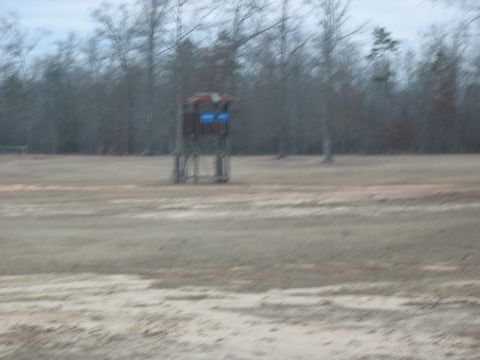 1978 Ford Bronco - A hunting blind is visible in an open field with a treeline behind it.