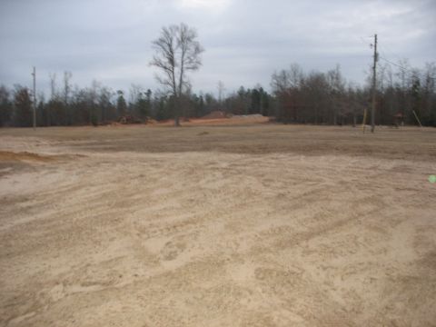 1978 Ford Bronco - A wide view of a construction site with bare trees and utility poles in the background.