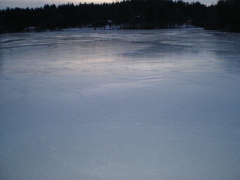 frozen lake with trees in background