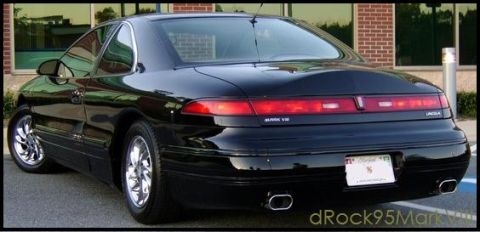 1996 Mercury Grand Marquis - Rear view of a black Lincoln Mark VIII coupe parked outside a brick building.
