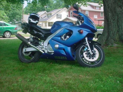 2004 Yamaha FZR600 - A blue Yamaha sportbike is parked on a grassy lawn in front of houses.