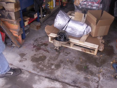 1986 Ford Bronco - A differential assembly is shown resting on a wooden pallet in a garage setting.