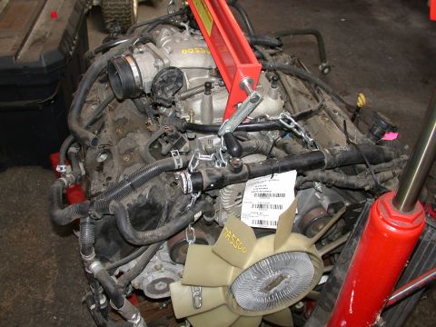 1964 Ford Ranchero - Engine assembly, likely removed from a vehicle, is being supported by an engine hoist.