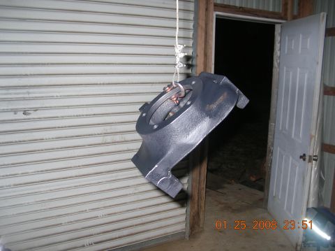 1991 Ford F-150 - A Dana 60 axle housing is suspended for inspection or work, with a workshop setting visible.