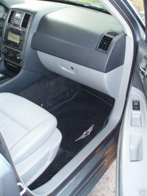2007 Chrysler 300 - The interior of a 2007 Chrysler 300 is shown, the dashboard, passenger seat, and a floor mat with the Chrysler wing emblem.