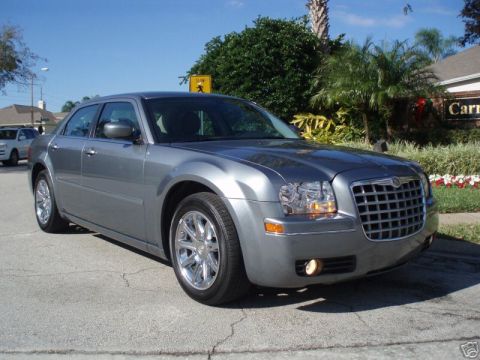 2007 Chrysler 300 - Gray 2007 Chrysler 300 sedan parked on a street with trees and houses in the background.