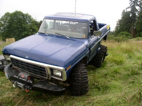 1979 Ford Bronco - This blue pickup truck features oversized tires and a winch, suggesting off-road capabilities.