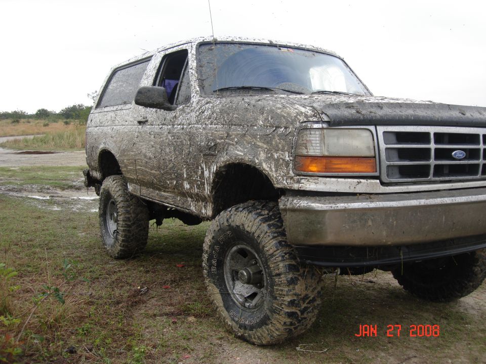 Mud-covered SUV, 3/4 front view, showing large tires and a dirty grille. Date stamp reads JAN 27 2008