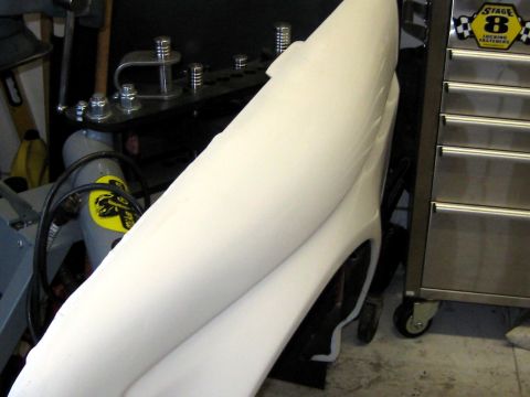 1996 Ford Bronco - A large white fiberglass or molded body panel leans in a garage workshop, next to a stainless steel rolling tool chest with a 'Stage 8 Lock…