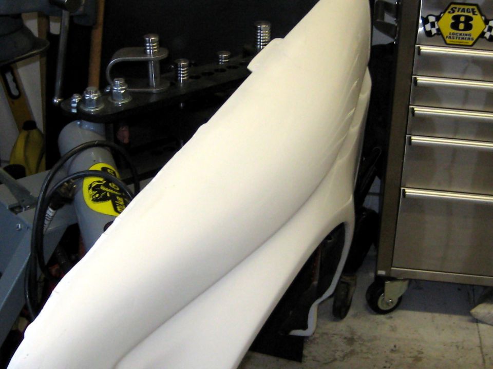 White molded panel leaning in garage beside stainless tool chest