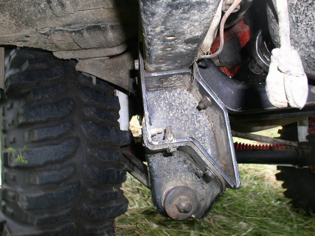 Close-up of a large off-road tire and suspension components, likely from a truck or SUV
