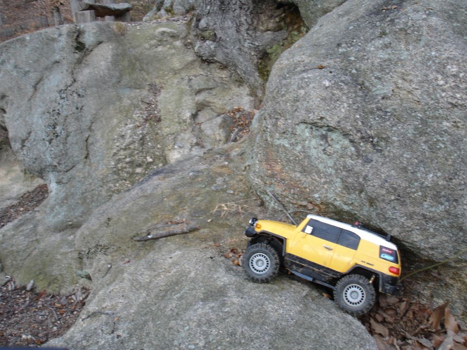 Yellow RC FJ Cruiser climbing over rocks