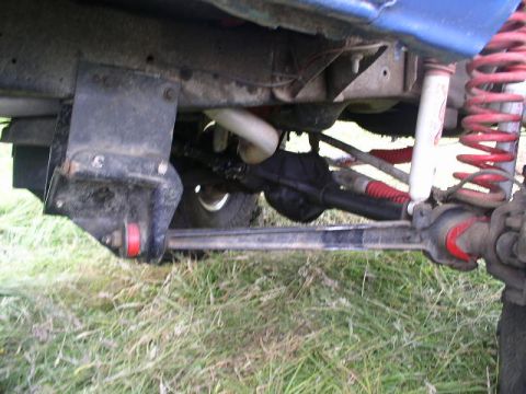 1979 Ford Bronco - The photo shows the undercarriage of a vehicle, focusing on the suspension and steering systems.