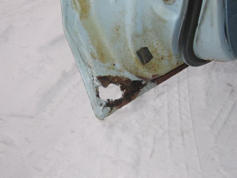 1991 Ford LTD Crown Victoria - Significant rust damage is visible on the lower edge of this car door panel.