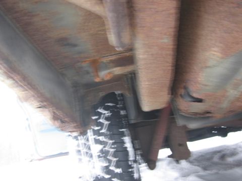 1991 Ford LTD Crown Victoria - Significant rust is visible on the undercarriage of this vehicle, with a tire and shock absorber in view.