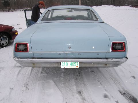 1991 Ford LTD Crown Victoria - A light blue 1969 Ford sedan is parked in the snow, showing its rear end and a license plate.