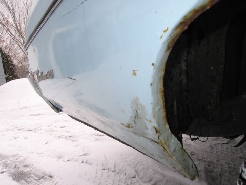1991 Ford LTD Crown Victoria - Rust is visible on the rear quarter panel of a light blue car parked in the snow.