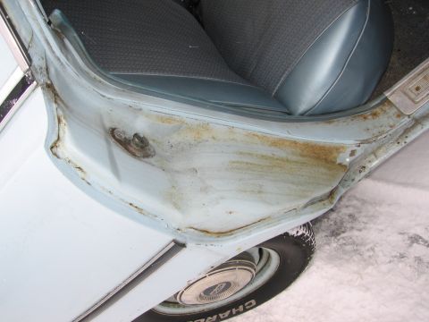 1991 Ford LTD Crown Victoria - Rust and damage are visible on the interior door frame of this vehicle, with a portion of the blue seat and tire also in view.