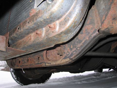 1991 Ford LTD Crown Victoria - Undercarriage of a vehicle showing significant rust on the frame and suspension components.