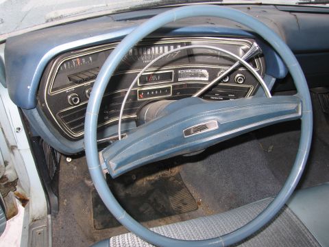 1991 Ford LTD Crown Victoria - The interior of a 1969 Ford Torino, with a blue dashboard and steering wheel, displays the instrument cluster and gear selector.