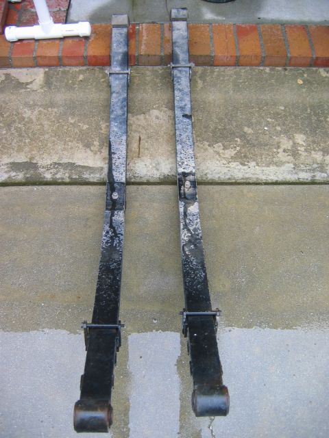 1983 Ferrari Enzo - Pair of used leaf springs shown on a wet concrete patio.