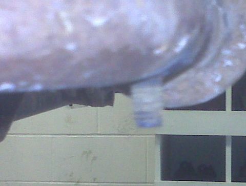 1996 Ford Bronco - A close-up view of a metal bracket with a bolt, showing some blue markings.