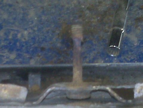 1996 Ford Bronco - Close-up view of a side step bracket mounting bolt, likely on the undercarriage of a vehicle.