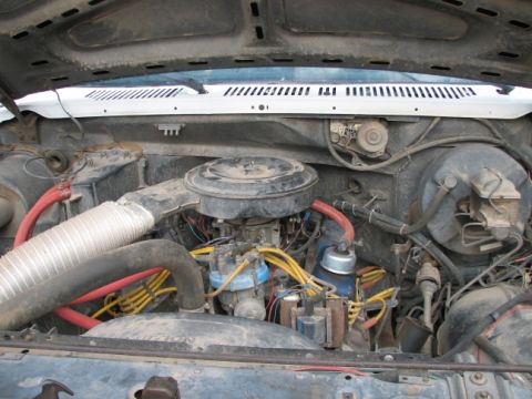 1982 Ford Bronco - The engine bay of a 1982 Ford Bronco is visible, with the hood open, revealing the engine components and wiring.