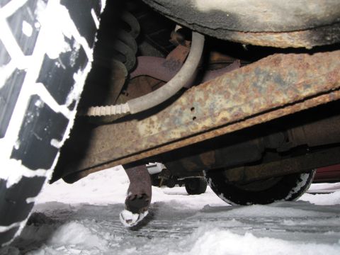 1991 Ford LTD Crown Victoria - Vehicle undercarriage visible in snowy conditions, with another car in the background.