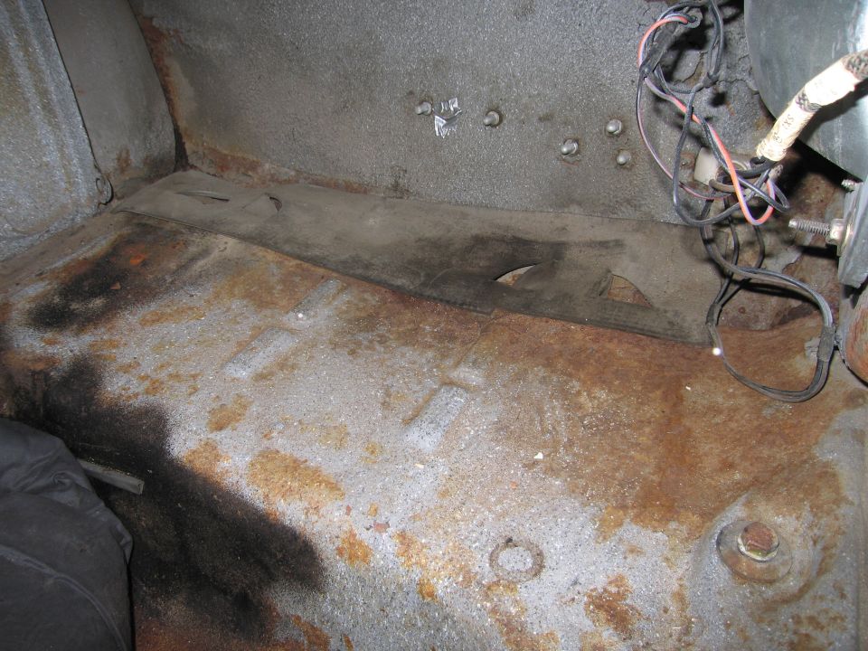 Rusty interior floor with visible wiring and bolts