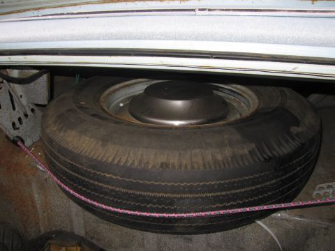 1991 Ford LTD Crown Victoria - Spare tire and hubcap located in the trunk of a car, showing signs of rust.