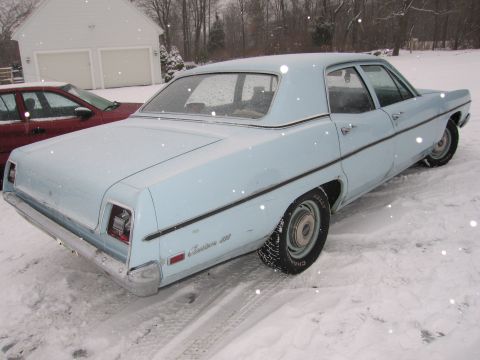 1991 Ford LTD Crown Victoria - A light blue 1969 Ford Custom 500 sedan is parked in the snow, with another vehicle visible in the background.