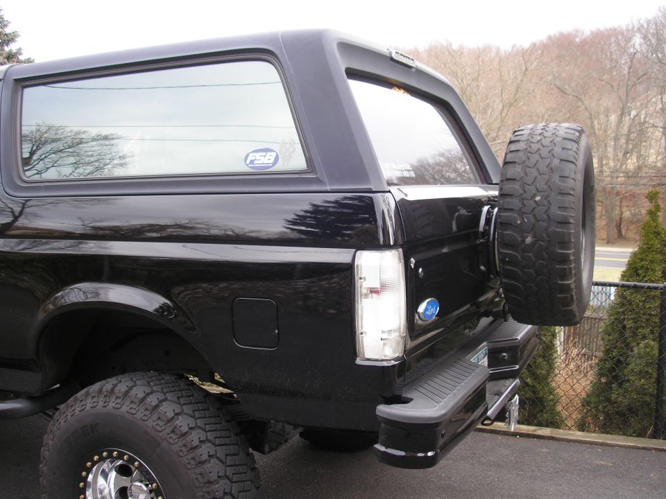 Black Ford Bronco, rear quarter view, spare tire mounted on back