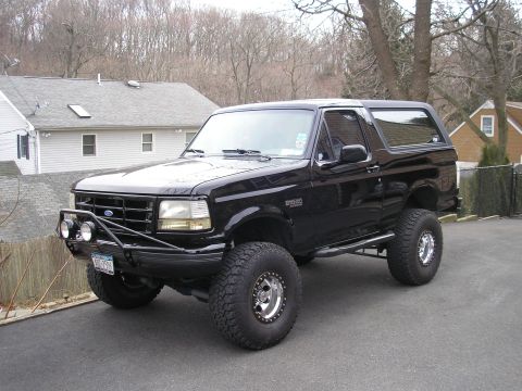 1995 Ford Bronco - This black Ford Bronco SUV, likely from the early to mid-1990s, is equipped with off-road enhancements.