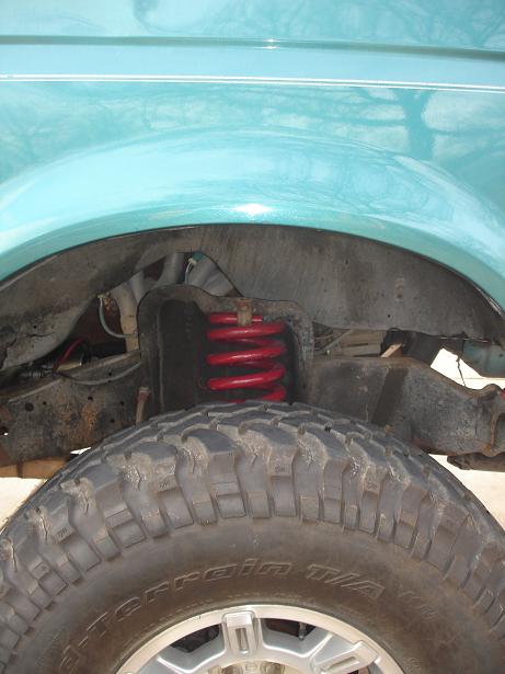 1996 Ford F-150 - This image shows the suspension and tire of a truck, likely from the mid-1990s, with visible 'All-Terrain T/A' markings on the tire.