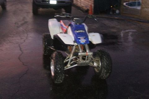 1999 Yamaha WARRIOR - ATV with blue and white bodywork on a wet surface.