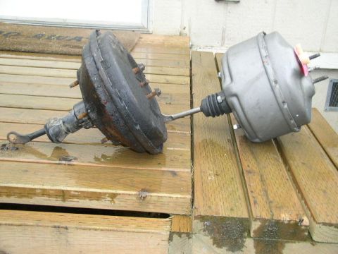 1979 Ford Bronco - A comparison of two brake boosters, one showing significant wear and rust, the other appearing more recently manufactured.