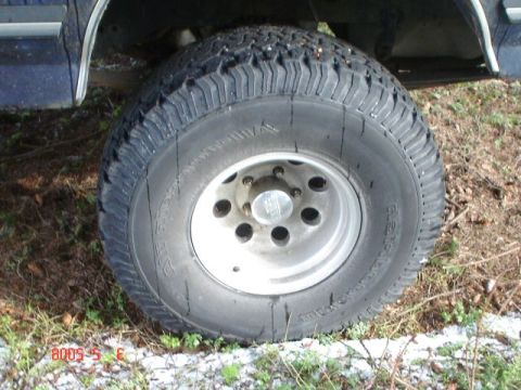 1990 Ford Bronco - Close-up of a vehicle's tire and wheel, showing the tread and rim details.