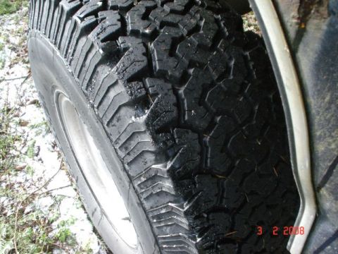 1990 Ford Bronco - A close-up view of a tire tread, showing its aggressive pattern and wet surface.