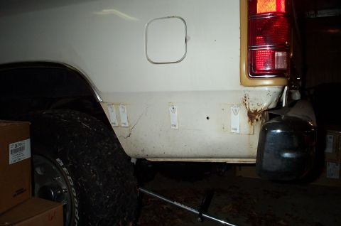 1996 Ford Bronco - The rear of a white SUV is shown, with visible rust and damage near the bumper area.