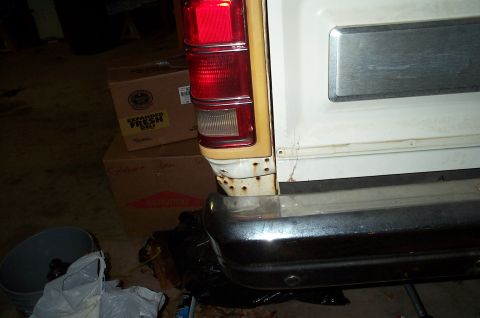 1996 Ford Bronco - Rear view of a white SUV showing damage and surrounding clutter.