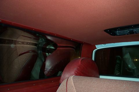 1996 Ford Bronco - Interior view of a vehicle with red seats and headliner, showing a black overhead console.