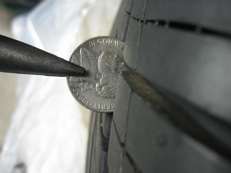 Nickel wedged in tire tread groove to check tread depth
