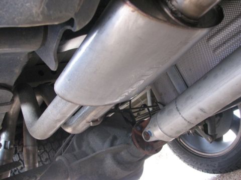 1991 Ford Bronco - Close-up view of the underbody exhaust system, showing the muffler and driveshaft, with a Supermotors.net watermark.