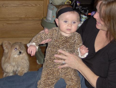 1978 Ford Bronco - A woman holds a baby while a small dog sits next to them indoors.
