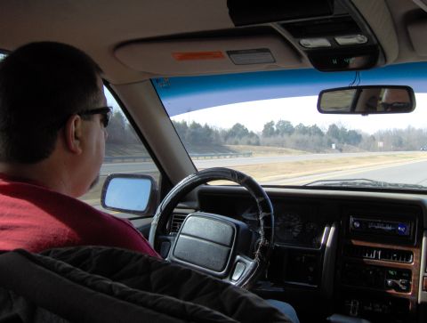 1978 Ford Bronco - View from inside a car as a man drives down a highway.